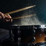 drummer-using-drum-sticks-hitting-snare-drum-with-splashing-water-black-background-studio-lighting-close-up-1.jpg
